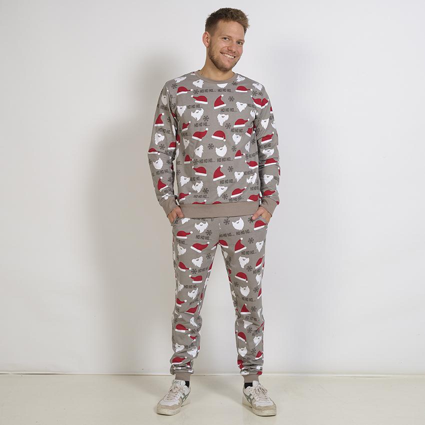 En poserande man klädd i en grå jultröja.